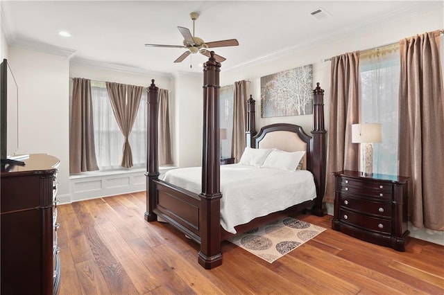 bedroom featuring ornamental molding, light wood-type flooring, and ceiling fan