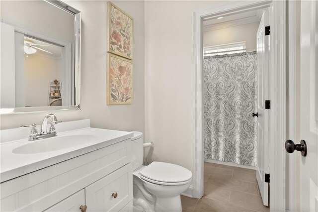 bathroom featuring toilet, ceiling fan, vanity, ornamental molding, and tile patterned flooring