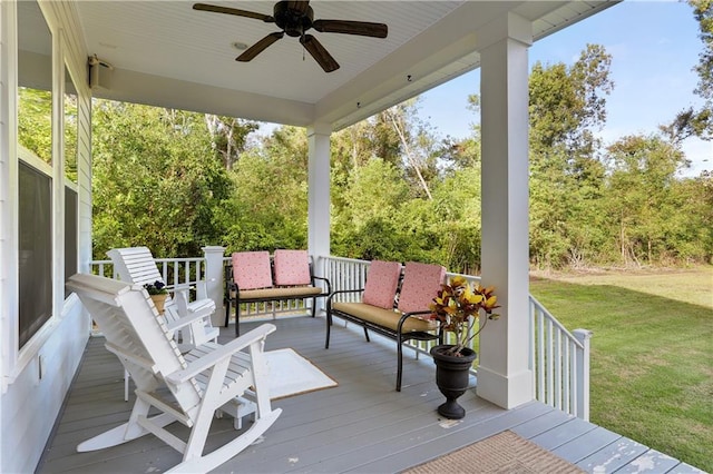 wooden terrace with a lawn and ceiling fan