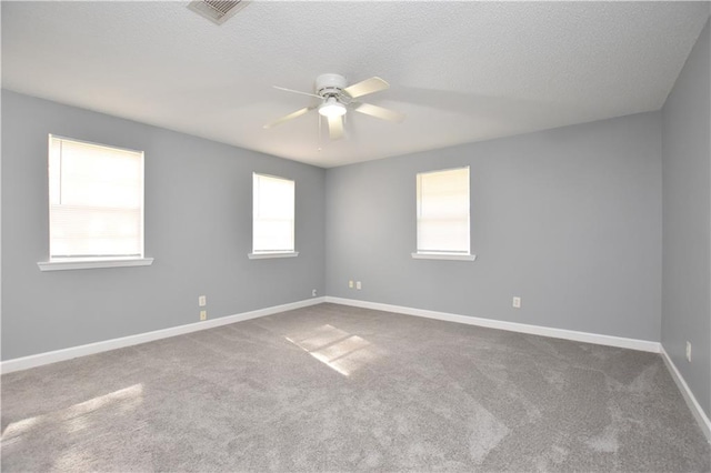 empty room with a textured ceiling, ceiling fan, and carpet floors