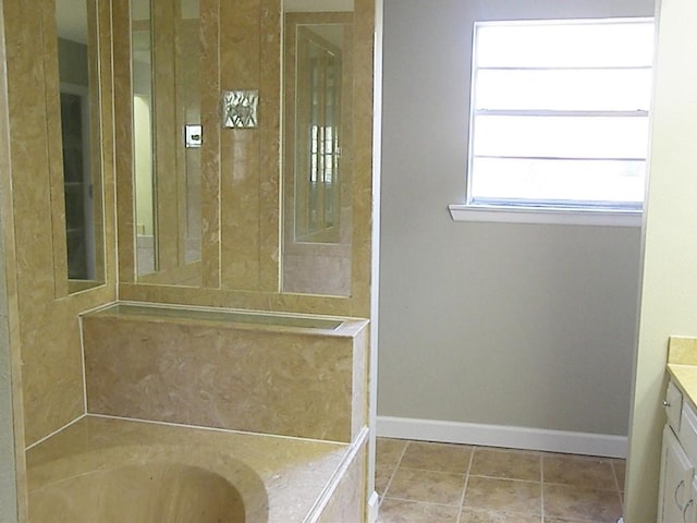 bathroom with tile patterned flooring, a washtub, and vanity