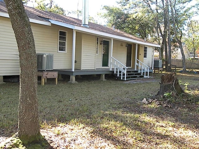 view of front of house with central AC unit and a front yard