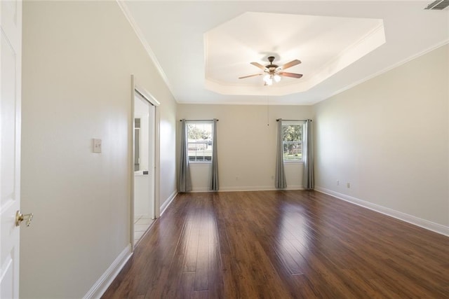 unfurnished room with ornamental molding, ceiling fan, a tray ceiling, and dark hardwood / wood-style flooring