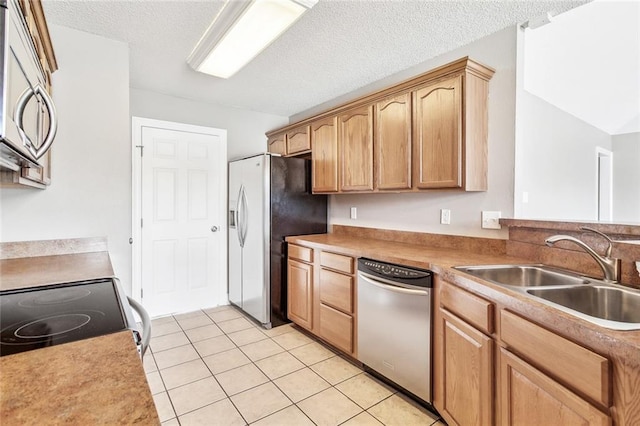 kitchen featuring light tile patterned floors, stainless steel appliances, a textured ceiling, and sink