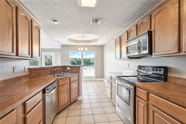 kitchen featuring an inviting chandelier, light tile patterned flooring, stainless steel appliances, sink, and decorative light fixtures