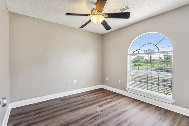 unfurnished room featuring ceiling fan, wood-type flooring, and a textured ceiling