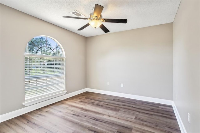 empty room with hardwood / wood-style floors, a textured ceiling, and ceiling fan