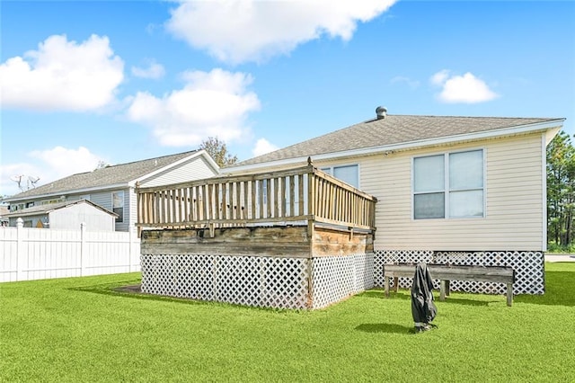 back of property with a wooden deck and a lawn