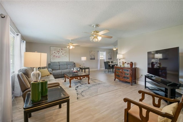 living room with ceiling fan, hardwood / wood-style floors, and a healthy amount of sunlight