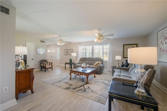 living room with ceiling fan and light hardwood / wood-style flooring