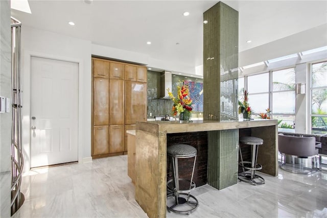 bar featuring wall chimney exhaust hood