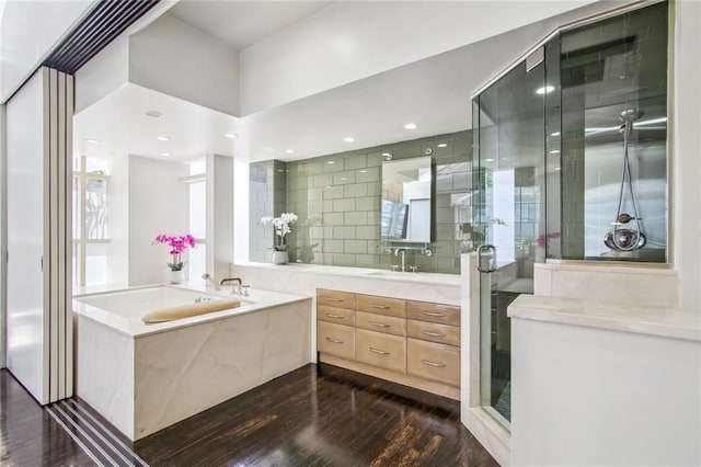 bathroom featuring vanity, tasteful backsplash, wood-type flooring, and separate shower and tub