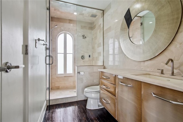 bathroom with walk in shower, hardwood / wood-style flooring, tile walls, toilet, and vanity