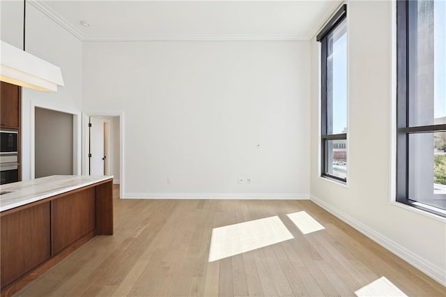 1001 Julia St Unit 2A, New Orleans, LA 70113 - unfurnished living room with ornamental molding, light wood-type flooring, and baseboards