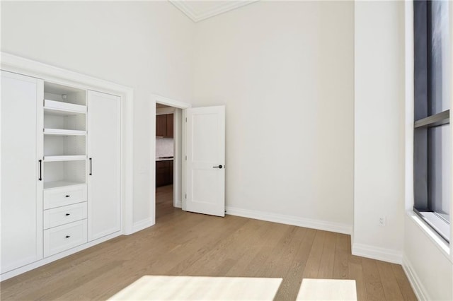 1001 Julia St Unit 2A, New Orleans, LA 70113 - unfurnished bedroom with light wood finished floors, baseboards, and crown molding