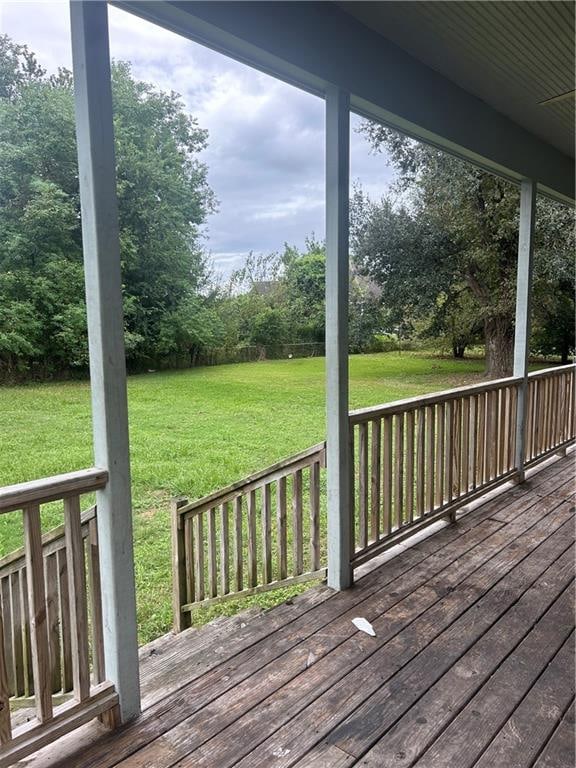 wooden terrace featuring a lawn