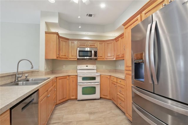 kitchen featuring appliances with stainless steel finishes, sink, and light brown cabinets