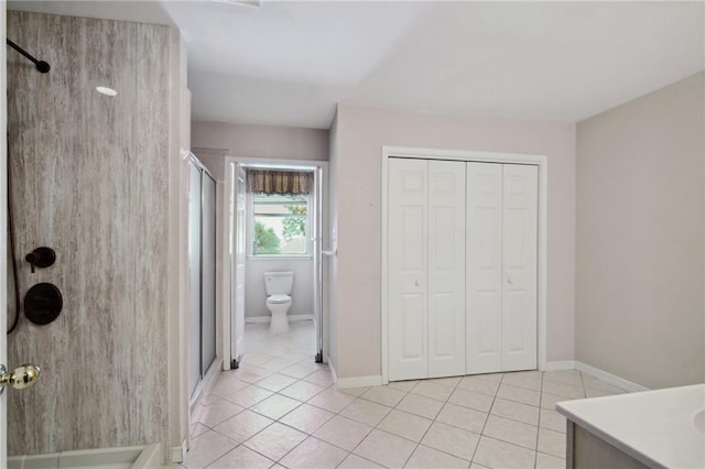 bathroom featuring toilet, walk in shower, vanity, and tile patterned floors