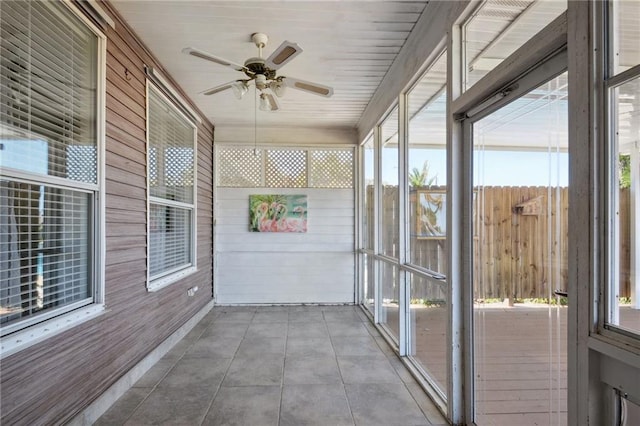 unfurnished sunroom with ceiling fan