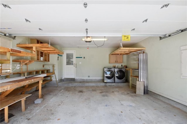 garage with a garage door opener and independent washer and dryer