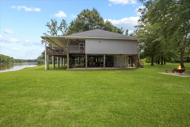 rear view of property featuring a patio area, a water view, a lawn, and ceiling fan