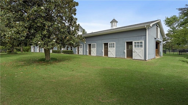 back of property featuring a lawn, an outbuilding, and a garage