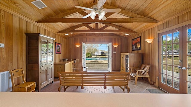 living area featuring lofted ceiling with beams, wood ceiling, and a healthy amount of sunlight