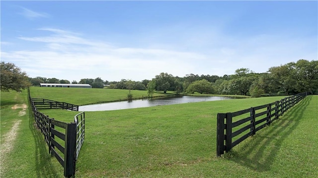 view of home's community featuring fence, a water view, and a yard