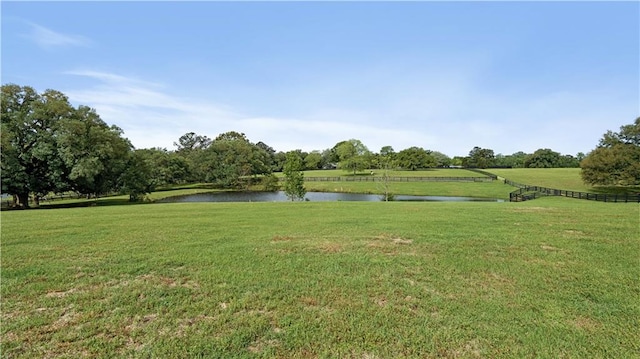 view of community with a yard, a water view, and a rural view