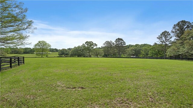view of yard featuring fence and a rural view