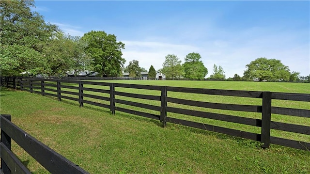 view of gate with a rural view and a yard