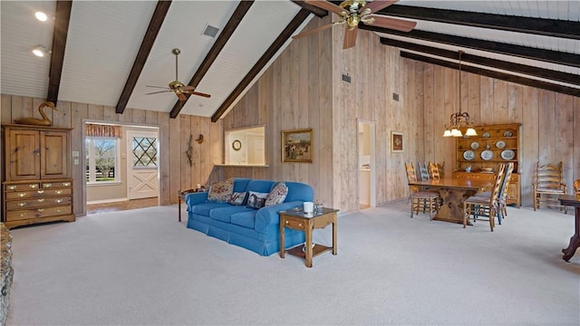 living area with ceiling fan, beam ceiling, and wooden walls
