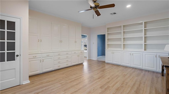 interior space with ornamental molding, light wood-type flooring, and ceiling fan