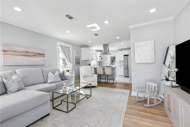 living room with crown molding and light hardwood / wood-style flooring