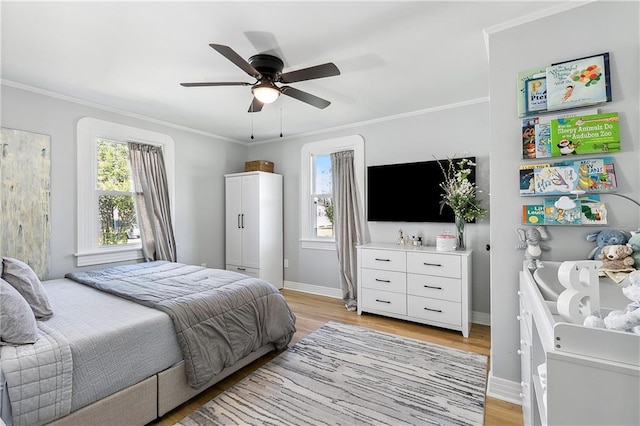 bedroom with light hardwood / wood-style floors, ornamental molding, and ceiling fan