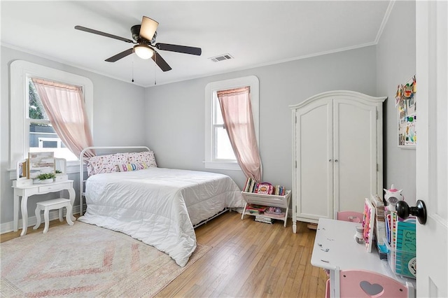 bedroom with crown molding, light wood-type flooring, and ceiling fan