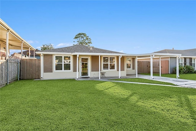 rear view of property featuring a lawn