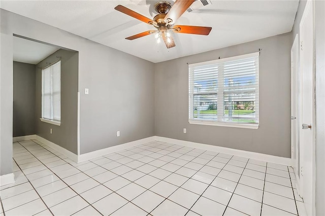 spare room with ceiling fan and light tile patterned floors