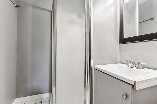 bathroom with vanity, an enclosed shower, and tile patterned floors