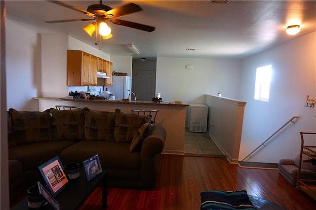 living room featuring sink, ceiling fan, and dark hardwood / wood-style flooring