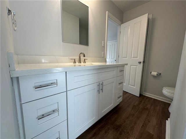 bathroom featuring toilet, hardwood / wood-style flooring, and vanity