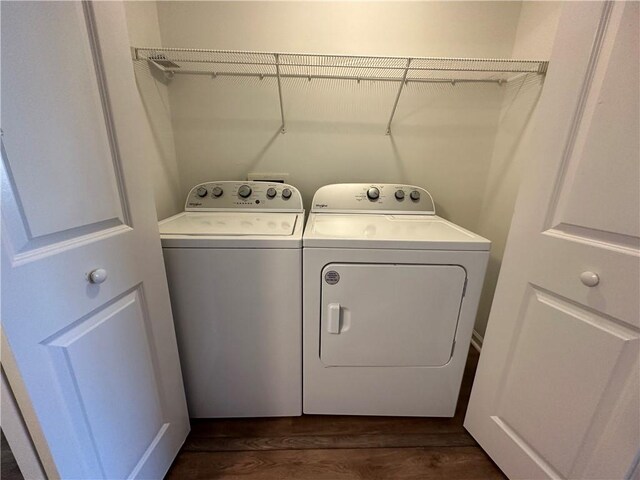 washroom with dark wood-type flooring and washer and dryer