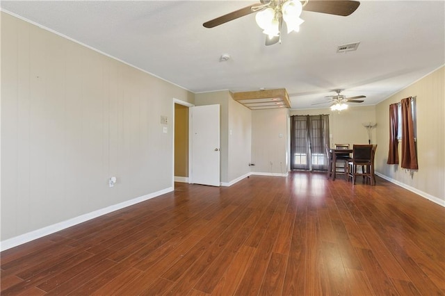 empty room with french doors, ornamental molding, dark wood-type flooring, and ceiling fan