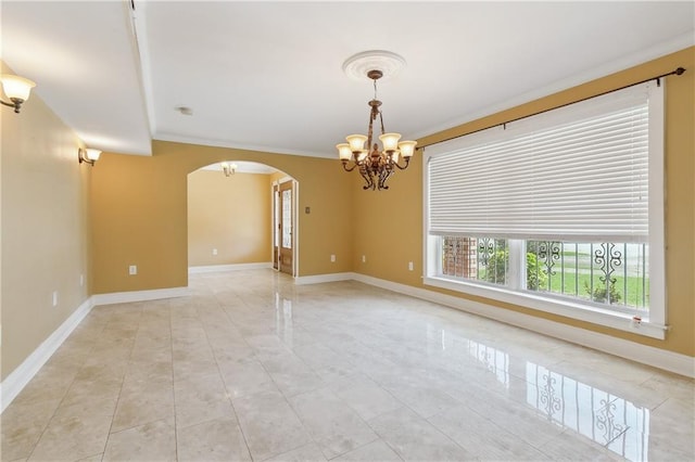 spare room with ornamental molding and an inviting chandelier