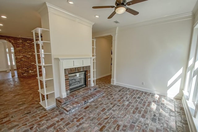 unfurnished living room featuring ornamental molding, a fireplace, and ceiling fan