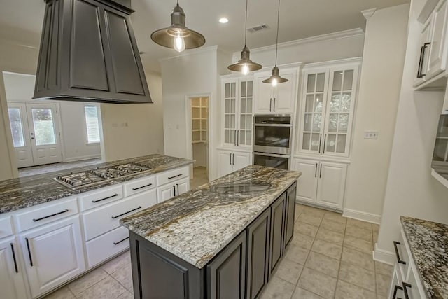 kitchen with dark stone counters, stainless steel appliances, glass insert cabinets, visible vents, and white cabinetry