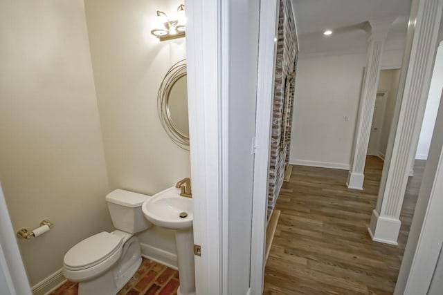 full bathroom with toilet, ornate columns, wood finished floors, and baseboards