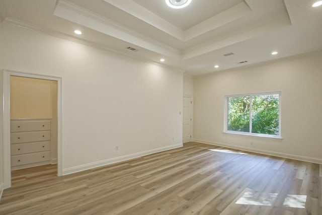 empty room featuring ornamental molding, visible vents, recessed lighting, and a tray ceiling