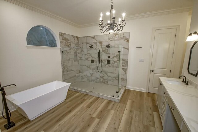 bathroom featuring crown molding, a chandelier, a marble finish shower, wood finished floors, and vanity