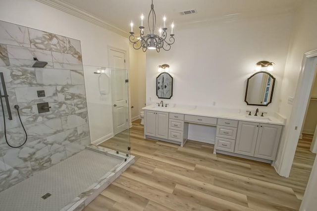 bathroom with a sink, a walk in shower, crown molding, visible vents, and wood finished floors